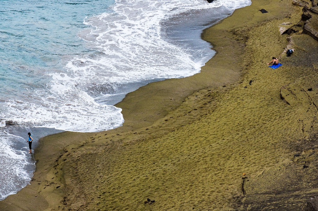 What may look like grass from afar, is really the Green Sands Beach on the Big Island of Hawaii. Image: Niels van Kampenhout, Alamy Stock Photo