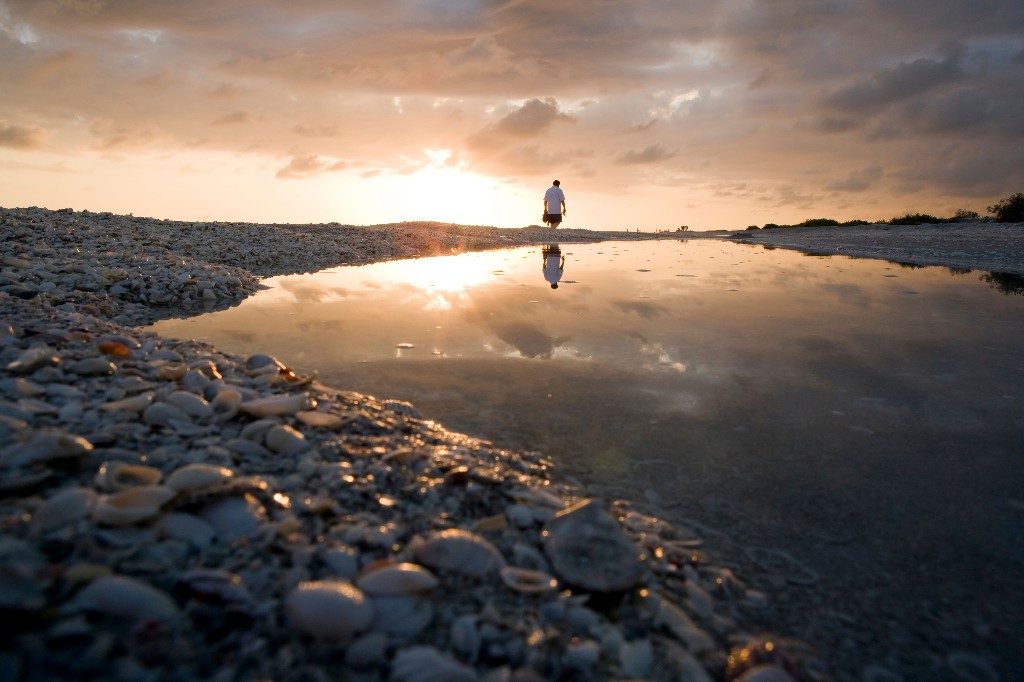 A visitor walks down Bowman's Beach at sunset on Sanibel Island, Florida. Image: Bill Gozansky, Alamy Stock Photo