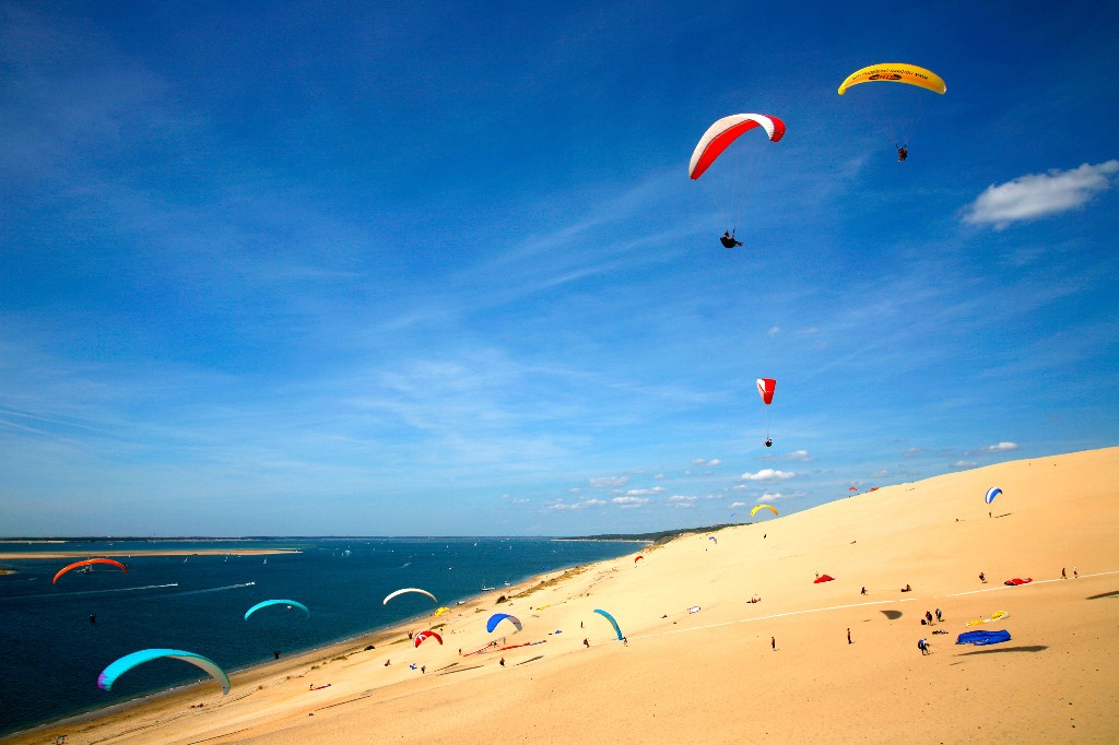 Paragliders fly over a dune on Corniche Beach in La Teste-De-Buch, France. Image: Nicolas Thibaut, Getty Images