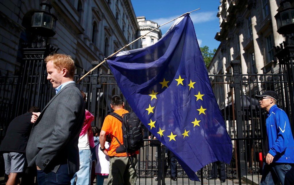 A man carries an EU flag outside Downing Street after Britain voted to leave the European Union. REUTERS/Neil Hall