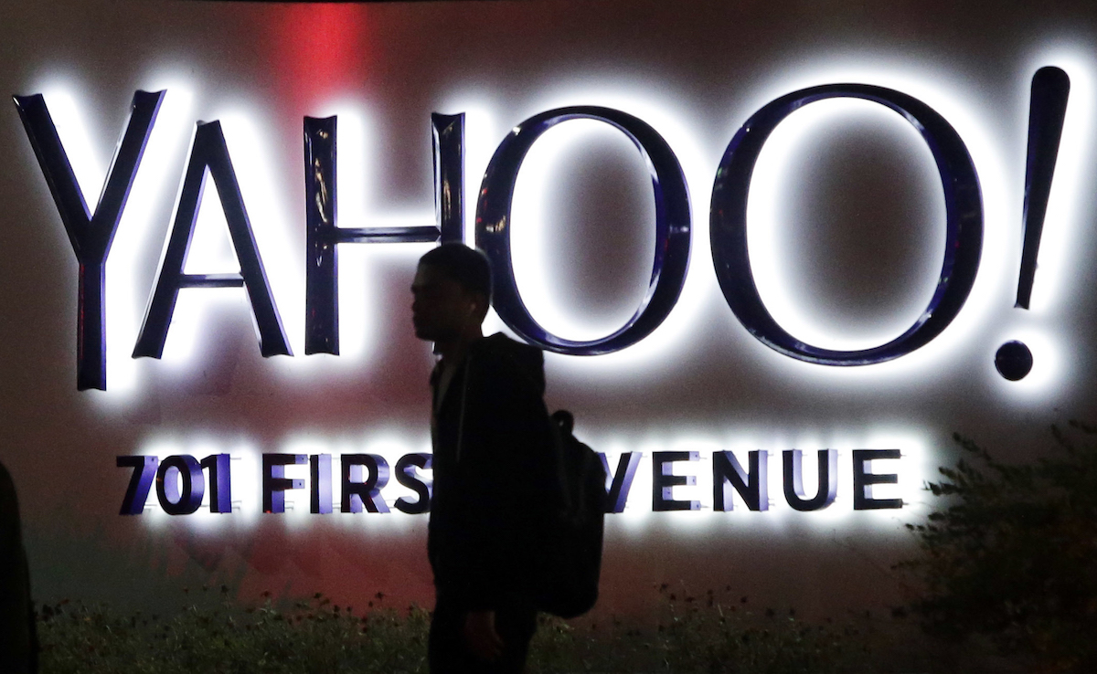 A person walks in front of a Yahoo sign at the company's headquarters in Sunnyvale, Calif. AP Photo/Marcio Jose Sanchez, File