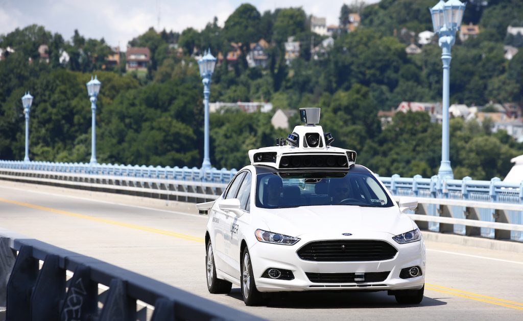 Uber employees test a self-driving Ford Fusion hybrid car, Thursday, Aug. 18, 2016, in Pittsburgh. Uber said that passengers in Pittsburgh will be able to summon rides in self-driving cars with the touch of a smartphone button in the next several weeks. The high-tech ride-hailing company said that an unspecified number of autonomous Ford Fusions with human backup drivers will pick up passengers just like normal Uber vehicles. Riders will be able to opt in if they want a self-driving car, and rides will be free to those willing to do it, spokesman Matt Kallman said. (AP Photo/Jared Wickerham)