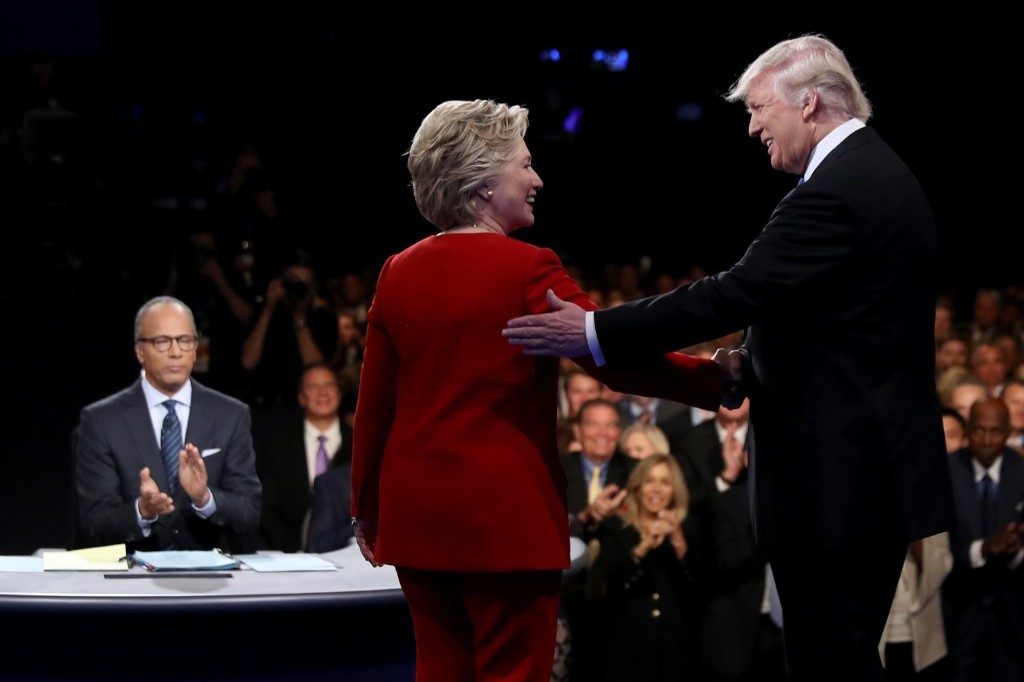 Hillary Clinton shakes hands with Donald Trump as moderator Lester Holt looks on. Joe Raedle/Getty Images