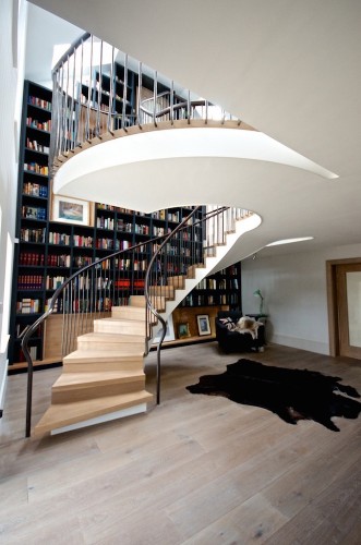 Spiral Staircase Effortlessly Flows by Floor-to-Ceiling Bookcase