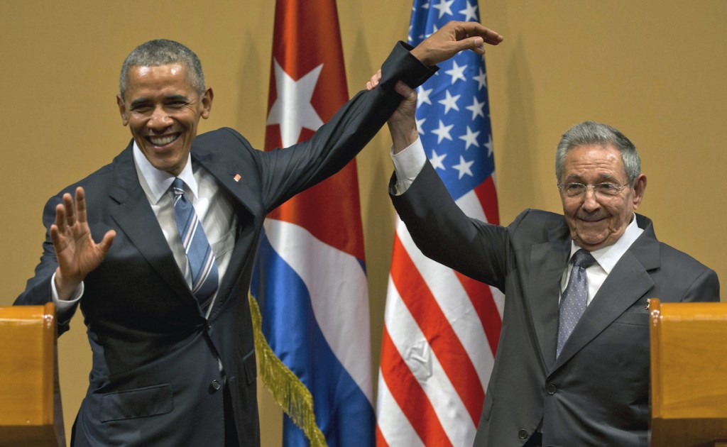 Cuban President Raul Castro, right, lifts up the arm of President Barack Obama at the conclusion of their joint news conference at the Palace of the Revolution, Monday, March 21, 2016, in Havana, Cuba. (AP Photo/Ramon Espinosa)
