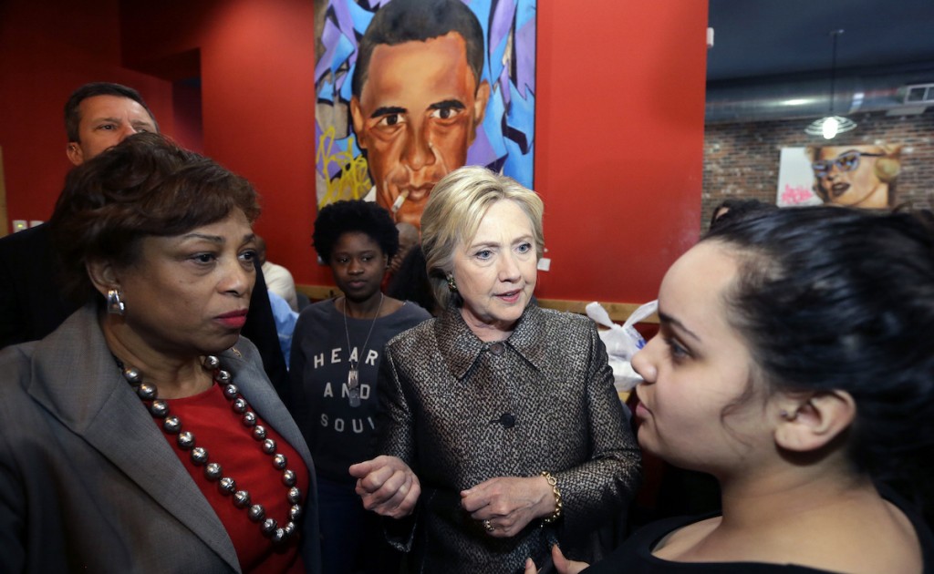 Hillary Clinton, center, and Rep. Brenda Lawrence, left, speak with a guest at Kuzzo's Chicken & Waffles, Friday, March 4, 2016, in Detroit. (AP Photo/Carlos Osorio)