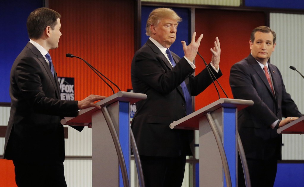 Donald Trump shows off the size of his hands as rivals Marco Rubio and Ted Cruz look on at the start of the Republican presidential candidates debate in Detroit, Michigan, March 3, 2016. REUTERS/Jim Young