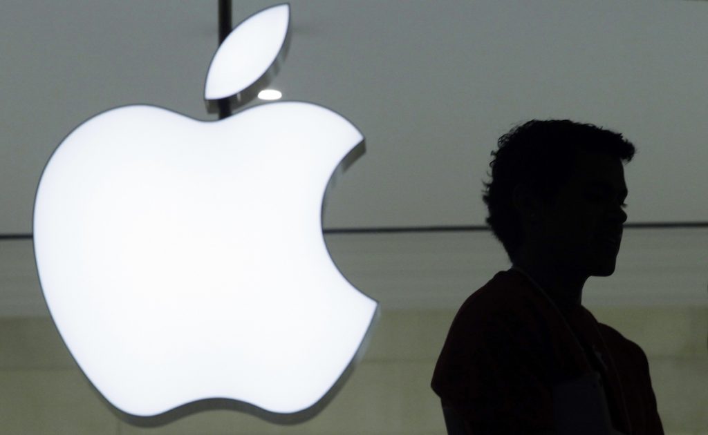 A person stands near the Apple logo at the company's store in Grand Central Terminal, in New York. AP Photo/Mark Lennihan, File