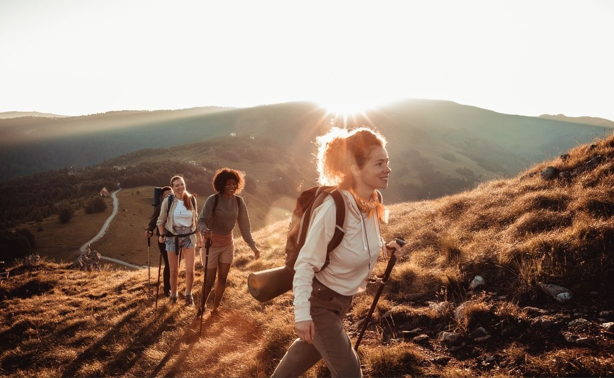 Hikers on a hill at sunset.