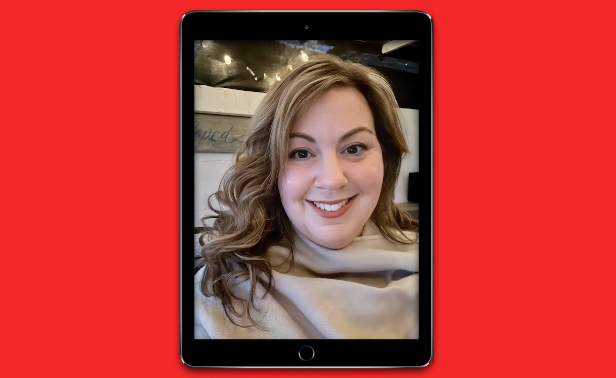 Headshot of Nicole Biscotti in a black iPad fram, against a red background