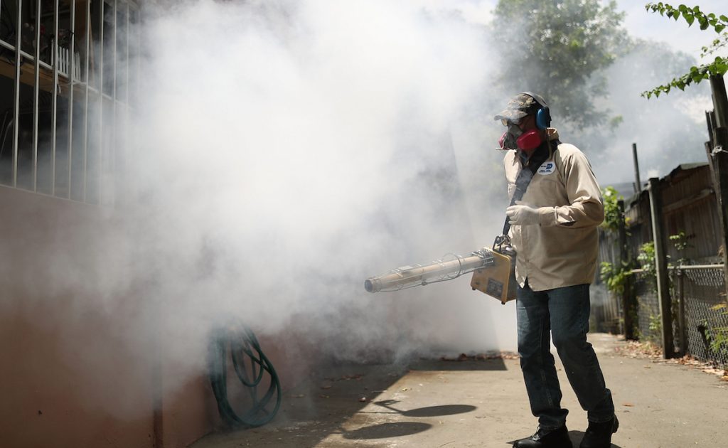 MIAMI, FL - AUGUST 02: Carlos Varas, a Miami-Dade County mosquito control inspector, uses a Golden Eagle blower to spray pesticide to kill mosquitos in the Wynwood neighborhood as the county fights to control the Zika virus outbreak on August 2, 2016 in Miami, Florida. There is a reported 14 individuals who have been infected with the Zika virus by local mosquitoes. (Photo by Joe Raedle/Getty Images)